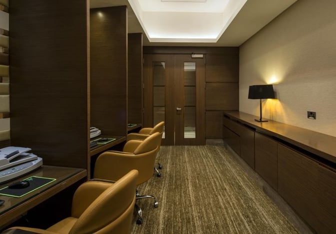 The business center in the Ahlan First Class Lounge features workstations with computers and a printer for passenger use.