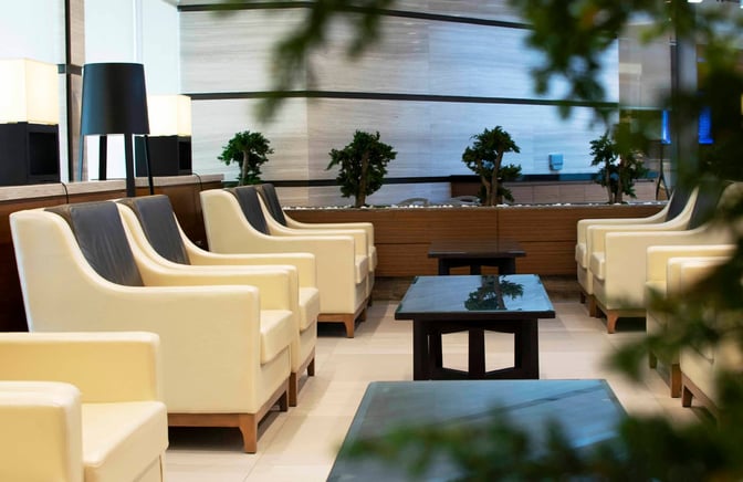 Seating area in the Ahlan First Class Lounge at Dubai International Airport features armchairs and tables, offering a comfortable waiting space.