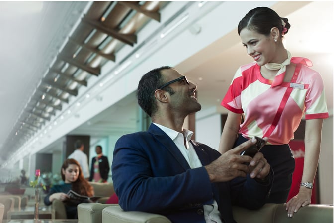 The seating area in marhaba Lounge at Dubai International Airport Terminal 3 Concourse A features comfortable chairs with staff attending to guests.