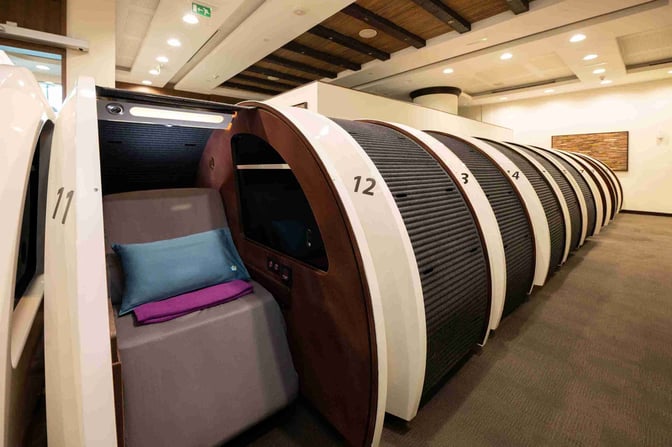 The Sleepover Lounge at Dubai International Airport Terminal 3 Concourse A features individual sleeping pods with numbered compartments for passenger rest and privacy.