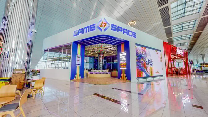 The Game Space at Dubai International Airport features an entrance with gaming stations and a prominent sign inviting travelers inside.