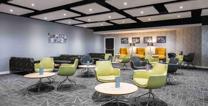 Seating area in the Escape Lounge at East Midlands Airport features various chairs and tables for relaxation and socializing.