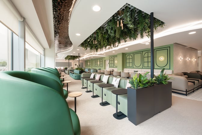 The seating area in Edinburgh Airport's Escape Lounge features individual chairs and couches with small tables and decorative plants.