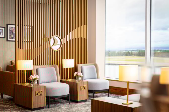 Seating area in the Turkish Airlines Lounge at Edinburgh Airport features comfortable chairs, side tables with lamps, and airport views.
