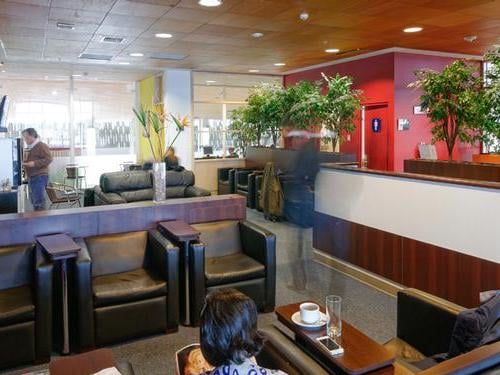 The Salones VIP Pacific Club lounge at El Tepual International Airport features comfortable seating areas with tables for dining and relaxation.