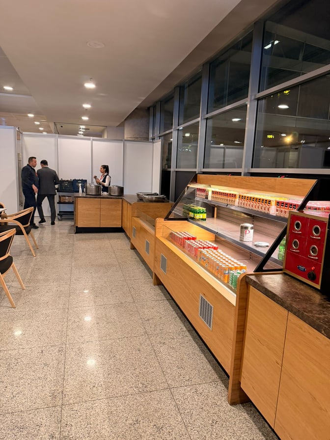 The Primeclass Pop-Up Lounge at Esenboğa International Airport features a self-serve beverage station with various drink options and seating nearby.