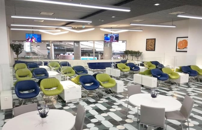 The CIP Lounge at Faro International Airport features seating with individual tables and televisions, providing a comfortable waiting area for travelers.