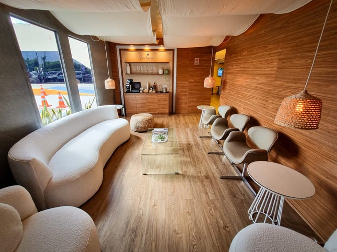 The Blue Lounge at Fernando de Noronha Airport features a seating area with a coffee station and a variety of chairs.