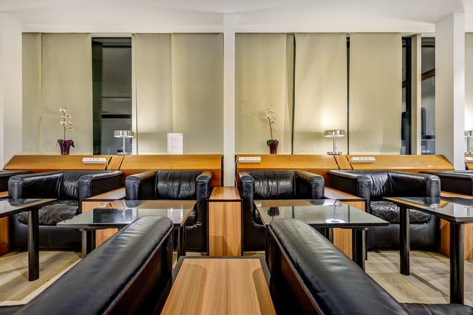 LuxxLounge at Frankfurt Airport features comfortable seating with individual tables and power outlets, providing a relaxing space for travelers.