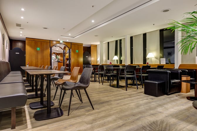 The LuxxLounge at Frankfurt Airport features a seating area with tables, chairs, and lamps, providing a comfortable space for travelers.