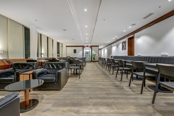 LuxxLounge at Frankfurt Airport features a spacious seating area with leather armchairs and tables, providing a comfortable waiting environment.