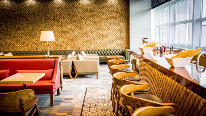 The Primeclass Lounge at Frankfurt Airport features a bar with counter seating and a variety of snacks and condiments available.