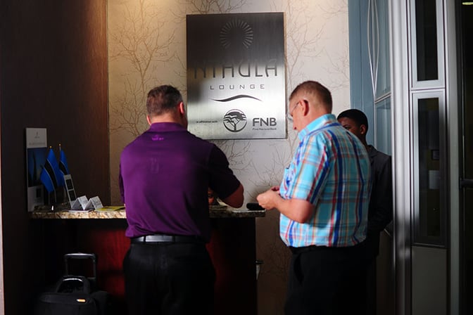 The entrance to Nthula Lounge at Sir Seretse Khama International Airport features a reception desk for guest check-in.