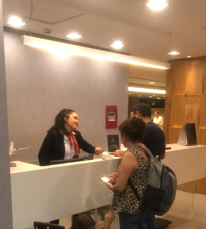 The reception area of GOL Premium Lounge at Rio de Janeiro–Galeão Airport features a staffed counter assisting passengers.
