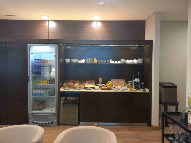 The Comodoro by AMAE Lounge at General Enrique Mosconi International Airport features a self-serve food area with snacks, beverages, and coffee.