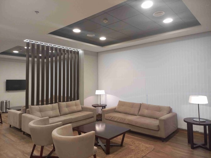 The seating area in Comodoro by AMAE Lounge at General Enrique Mosconi International Airport features sofas, armchairs, and side tables.