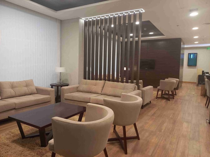 The Comodoro by AMAE Lounge at General Enrique Mosconi International Airport features comfortable seating with sofas and chairs for relaxation.