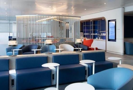The Air France - KLM Lounge at Geneva International Airport features seating areas with individual tables and lamps for passenger comfort.
