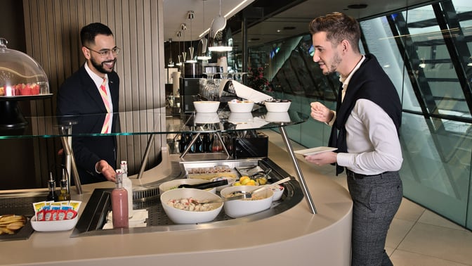 The food service area at marhaba Lounge in Geneva International Airport offers a selection of salads and condiments for guests.