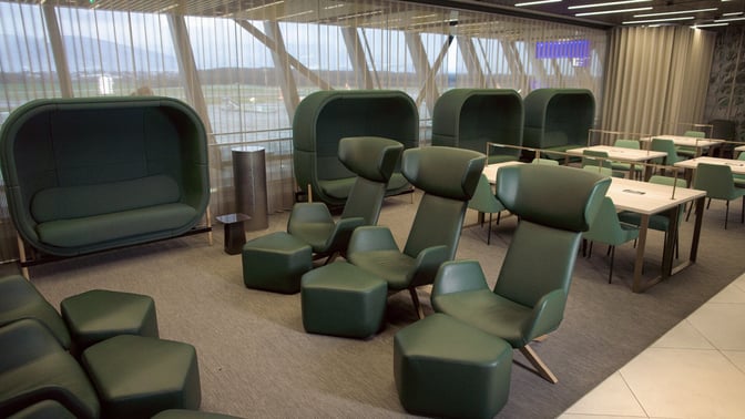 The seating area in the marhaba Lounge at Geneva International Airport features ergonomic chairs and tables with views of the runway.