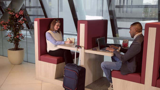 Booth seating in the marhaba Lounge at Geneva International Airport offers semi-private workspaces with tables for laptops and personal items.