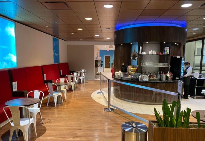 The KLM Crown Lounge at George Bush Intercontinental Airport features a self-serve bar area with seating and complimentary beverages.