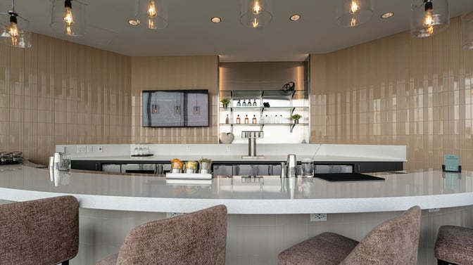 The Club GRR bar at Grand Rapids Airport offers a selection of beverages with counter seating and a modern serving area.