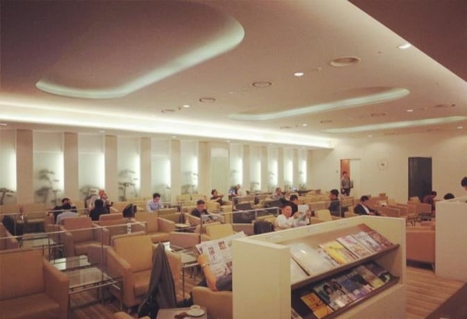 The seating area in Korean Air Lounge at Gimhae International Airport features comfortable chairs and a magazine rack for travelers.