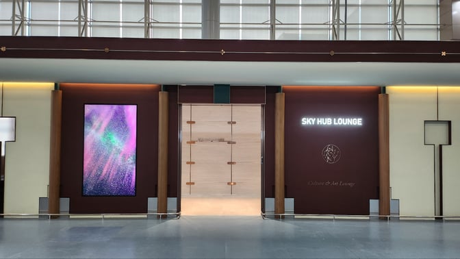 The entrance to the Sky Hub Lounge at Gimhae International Airport features a prominent sign and a digital display.