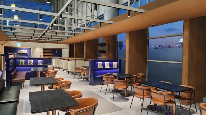 The seating area at N Sky Hub Lounge in Gimhae International Airport features tables and chairs for dining and relaxation.
