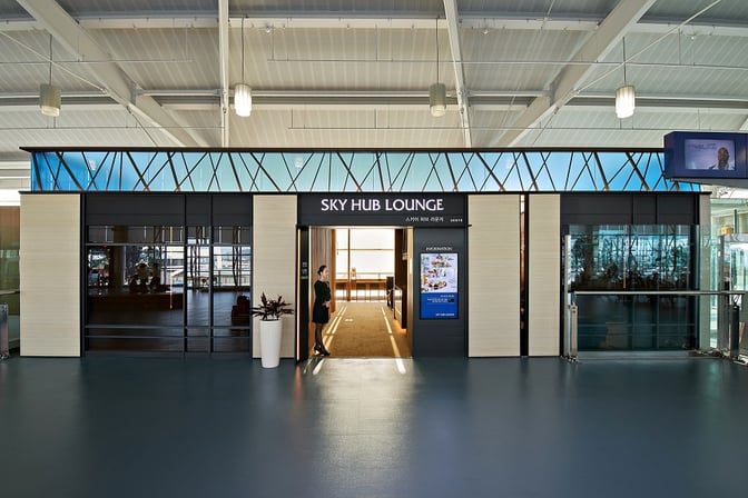 The entrance to the Sky Hub Lounge at Gimhae International Airport features a welcoming doorway with informational signage.