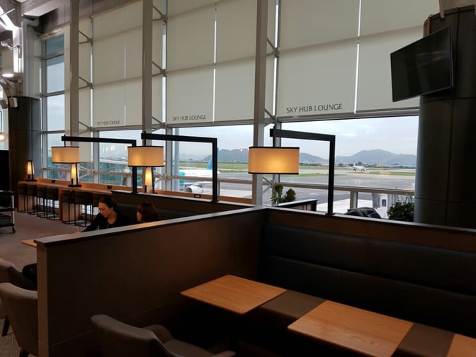 The Sky Hub Lounge at Gimhae International Airport features booth seating with views of the runway and ample natural light.