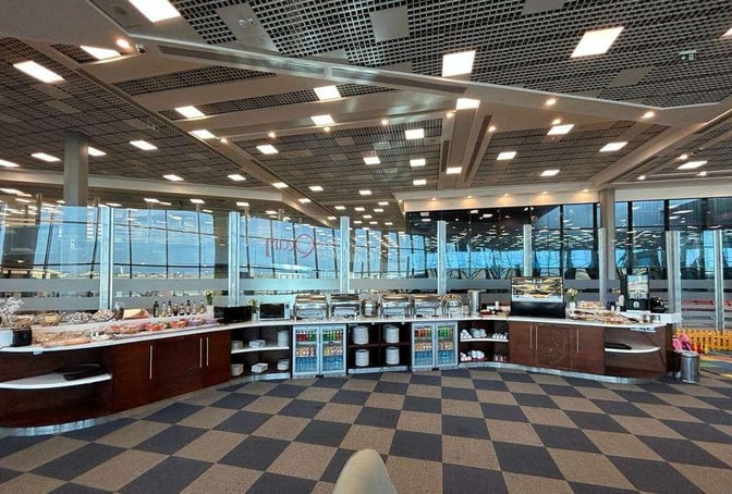 The Pearl Lounge at Sphinx International Airport features a self-serve buffet area with a variety of food and beverage options.