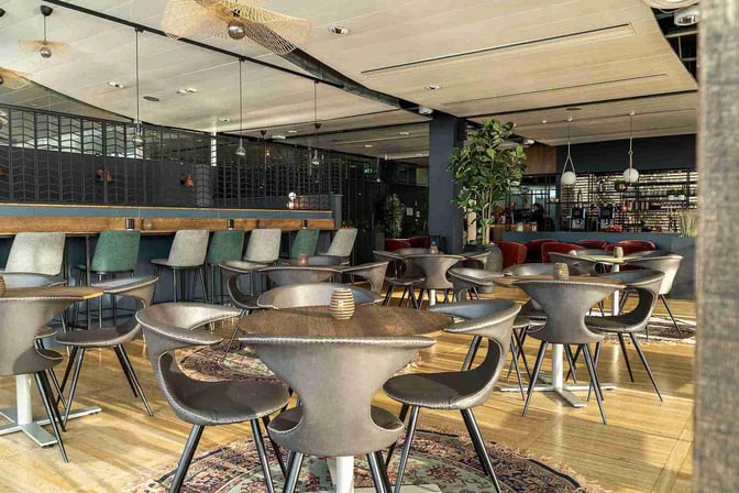 The Lounge by Menzies Aviation at Gothenburg Landvetter Airport features a seating area with tables and chairs for dining and relaxation.
