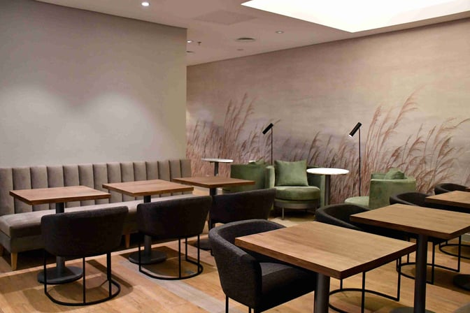 Seating area in Mendoza by AMAE Lounge at Governor Francisco Gabrielli International Airport features tables, chairs, and booth seating for travelers.