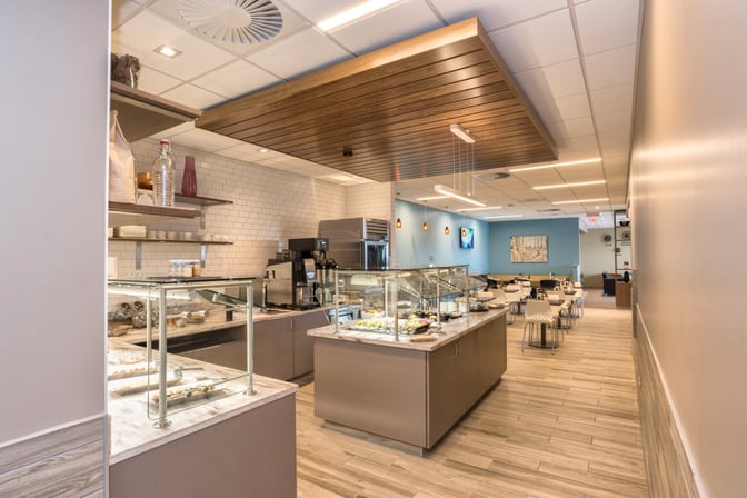The Escape Lounge at Greenville–Spartanburg International Airport features a self-serve food area with various dishes and seating options.