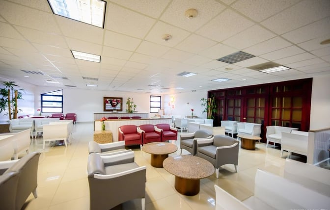The seating area in Sala Ambar at Gregorio Luperon International Airport features a variety of chairs and tables for passenger comfort.