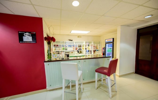 The bar area in Sala Ambar at Gregorio Luperon International Airport offers seating and a selection of beverages for guests.