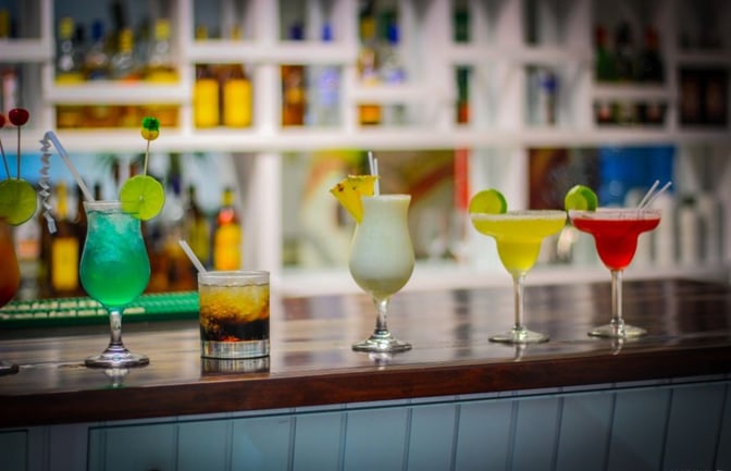 The bar at Sala Ambar in Gregorio Luperon International Airport offers a variety of colorful cocktails on a polished counter.