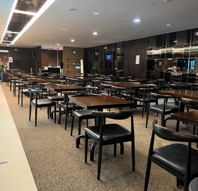 The Sagan Bisita VIP Lounge at Guam International Airport features a spacious seating area with multiple tables and chairs for guests.