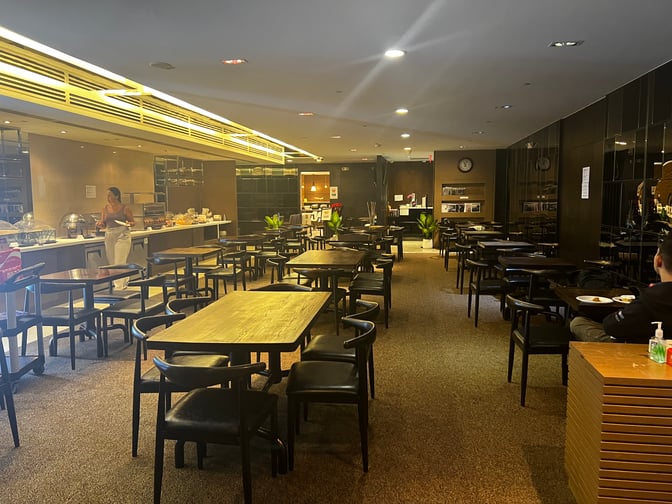 The Sagan Bisita VIP Lounge at Guam International Airport features a dining area with multiple tables and a self-serve food station.
