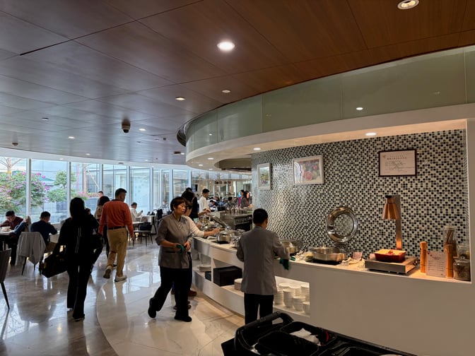 The China Southern First/Business Class Lounge at Guangzhou Baiyun International Airport features a self-serve buffet area with various dining options.