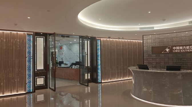 The entrance to the China Southern First/Business Class Lounge at Guangzhou Baiyun International Airport features a reception desk and VIP area.