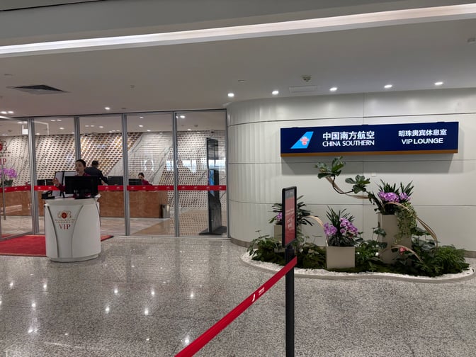 The entrance to the China Southern Skypearl Lounge at Guangzhou Baiyun International Airport is up the escelator and features a reception desk and VIP signage.