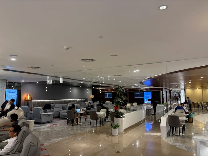 The China Southern Skypearl Lounge at Guangzhou Baiyun International Airport features a seating area with armchairs and tables for travelers.