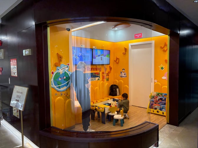 The children's play area in China Southern Skypearl Lounge features toys, seating, and a TV for entertainment at Guangzhou Baiyun International Airport.