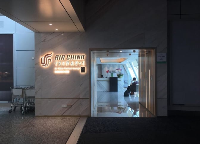 The entrance to the Air China First Class Lounge at Guangzhou Baiyun International Airport features a reception area and seating.