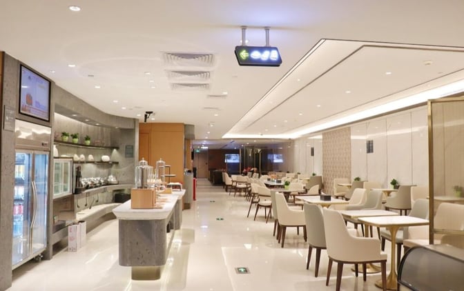 The Hainan Airlines First Class Lounge at Guangzhou Baiyun International Airport features a self-serve food area and spacious seating for travelers.