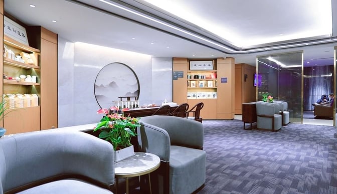 The Hainan Airlines First Class Lounge at Guangzhou Baiyun International Airport features comfortable seating and a tea display area for relaxation.