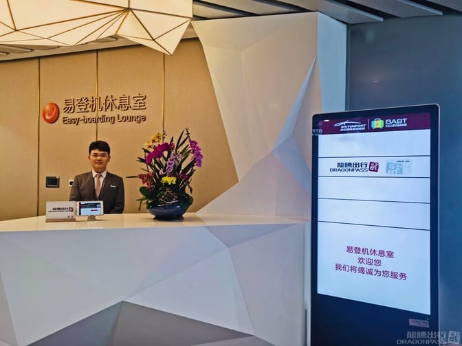 The Easy-boarding Lounge at Guangzhou Baiyun International Airport features a reception desk with a staff member and digital signage.